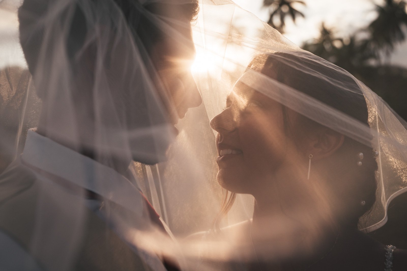 Liza et Emmanuel sous le voile au coucher du soleil, palmiers — Timi M. Bourdet