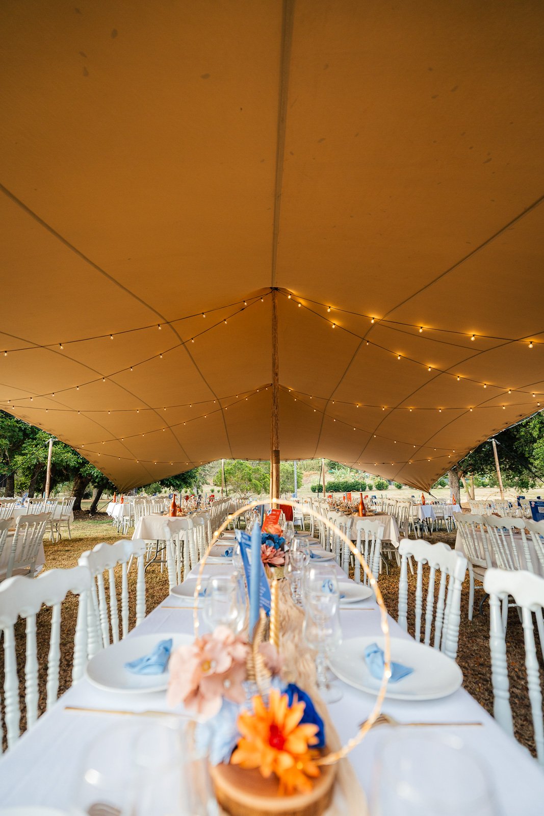Tables de réception sous chapiteau et guirlandes, mariage de Liza et Emmanuel — Timi M. Bourdet